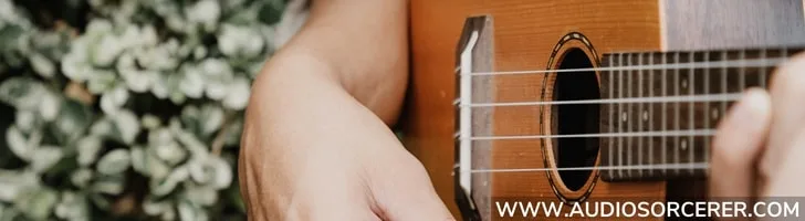 Closeup of a man playing a ukulele in the Ukulele Buddy review best ukulele lessons online blog article.