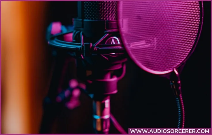 Picture of a condenser microphone in a studio with a shock mount in front of it.