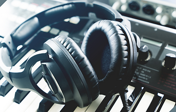Closed-back headphones sitting on a keyboard.