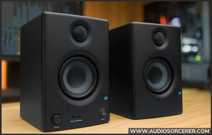 PreSonus Eris E3.5 studio monitors sitting on a wood table.