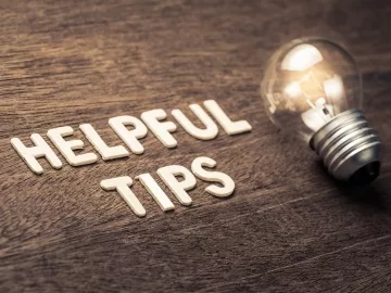 The words "Helpful Tips" with a light bulb on a wooden table.