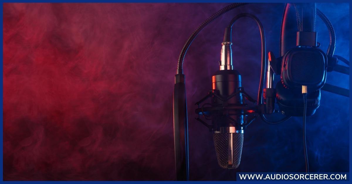 Condenser microphone on a stand with a pop filter and headphones close by.