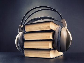 Headphones on a stack of books.