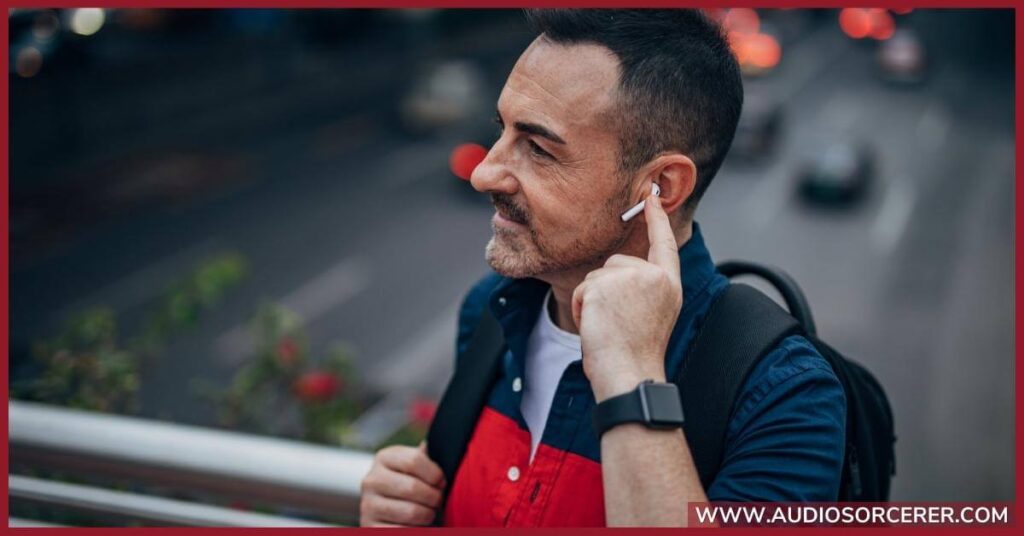 A man out-and-about in the city with wireless headphones in his ears.