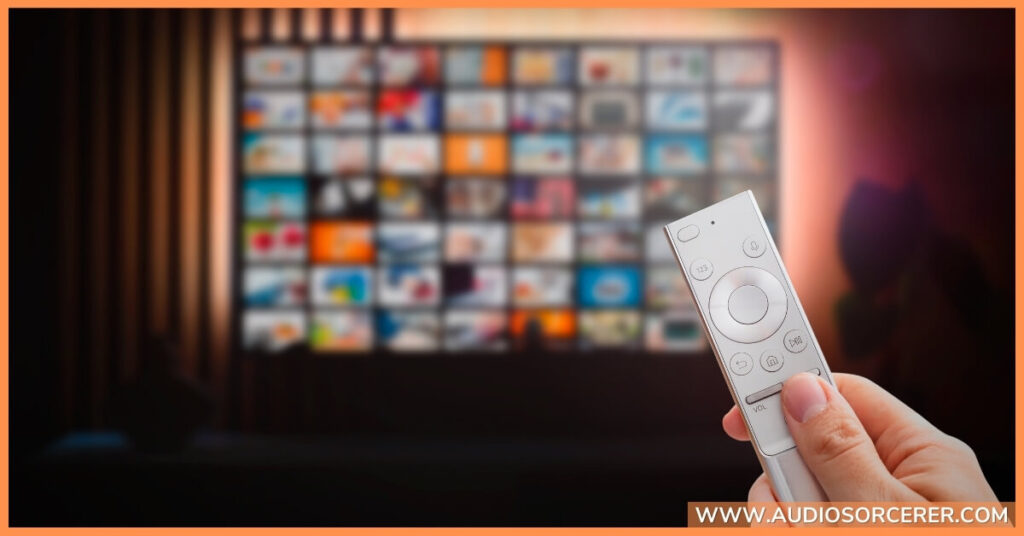 Closeup of a hand with a remote control scrolling through different streaming services.