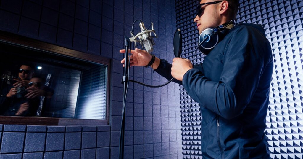 Singer in studio adjusting microphone placement to combat sibilance.