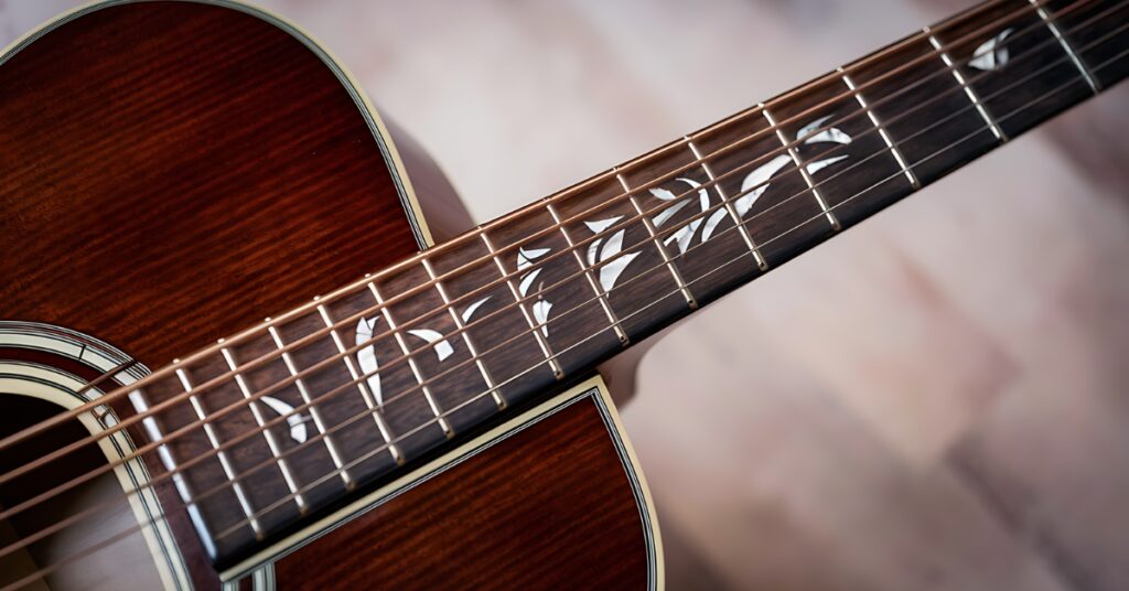Rosewood fretboard on an acoustic guitar.