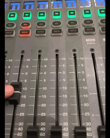 GIF of an audio engineer moving a fader on a mixing console to record level automation.